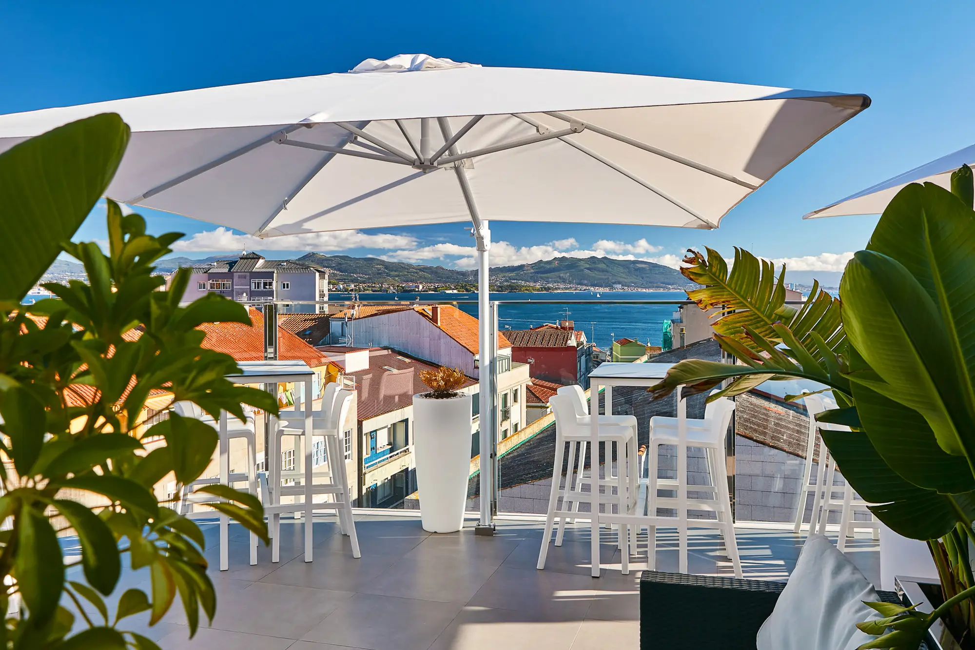Rooftop bar with a cantilever parasol over a sea view