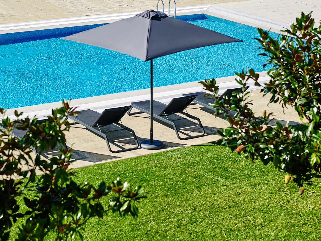 Poolside parasol shading sun loungers