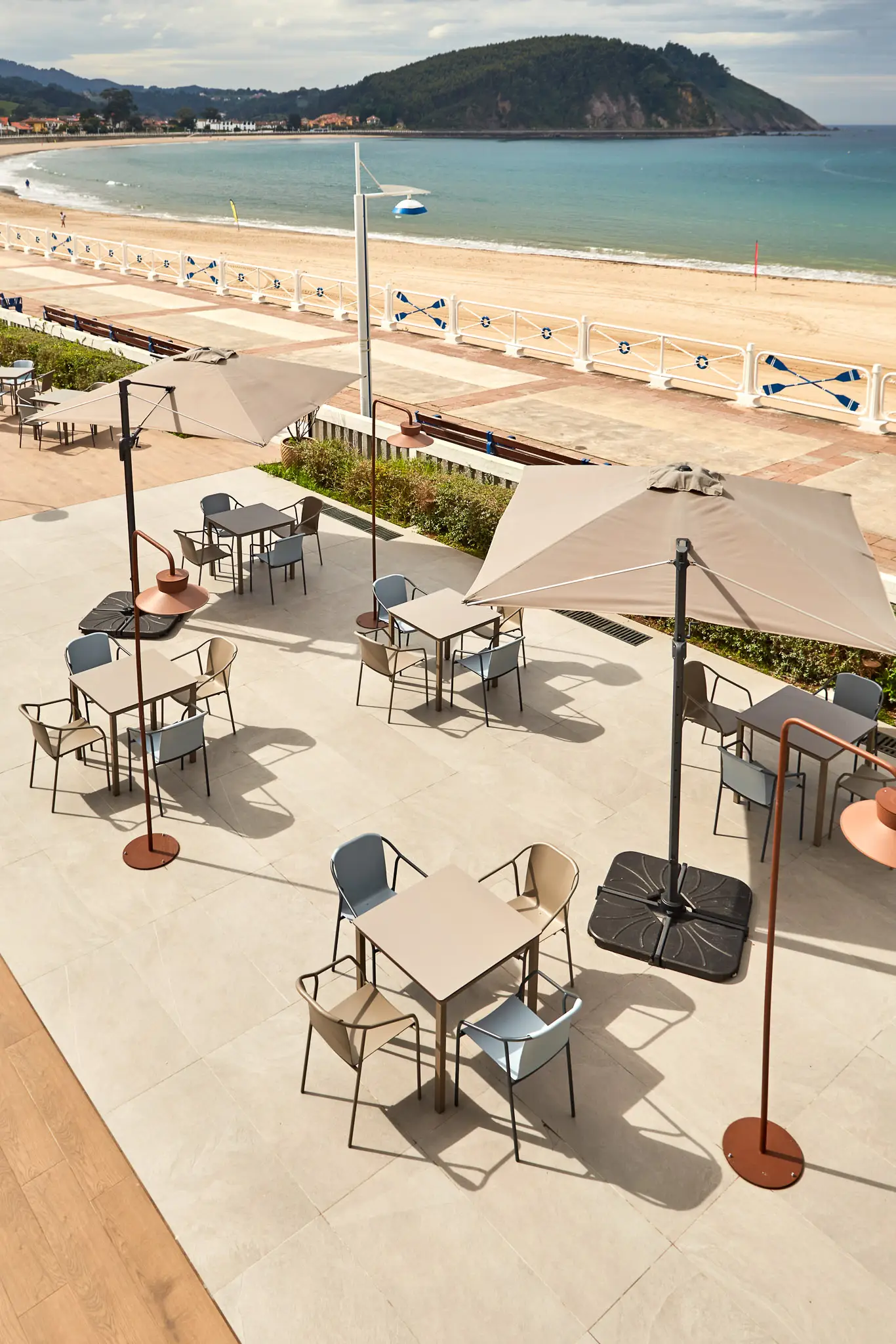 Seafront promenade terrace shaded by side-post parasols