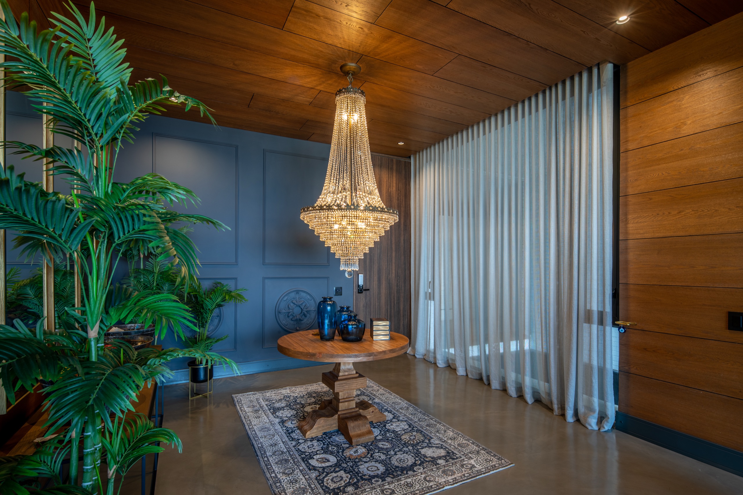 Crystal chandelier foyer with floor-to-ceiling sheer curtains