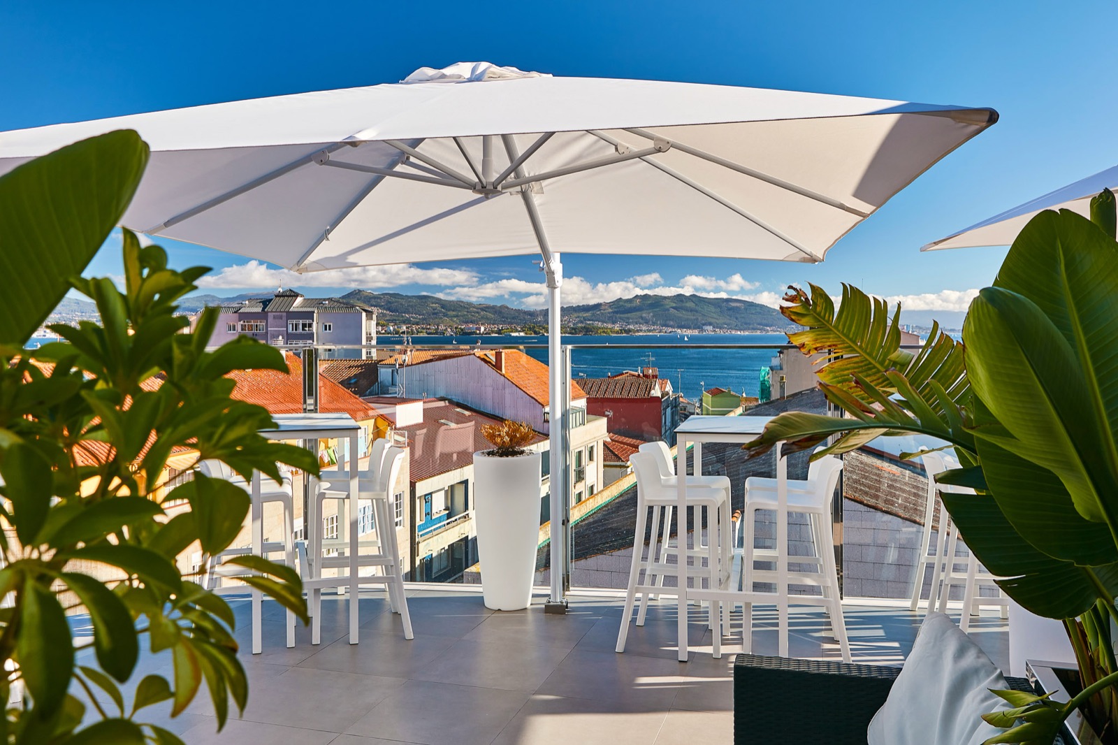 Rooftop bar with a cantilever parasol over a sea view