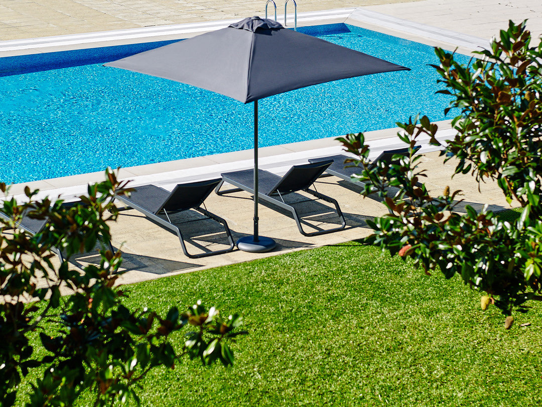 Poolside parasol shading sun loungers