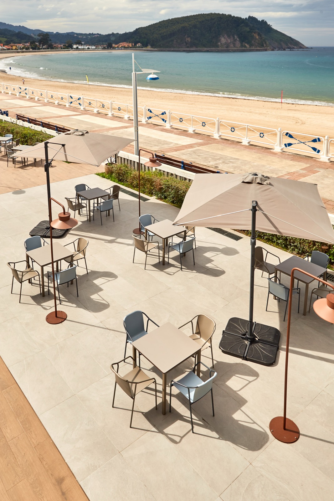 Seafront promenade terrace shaded by side-post parasols