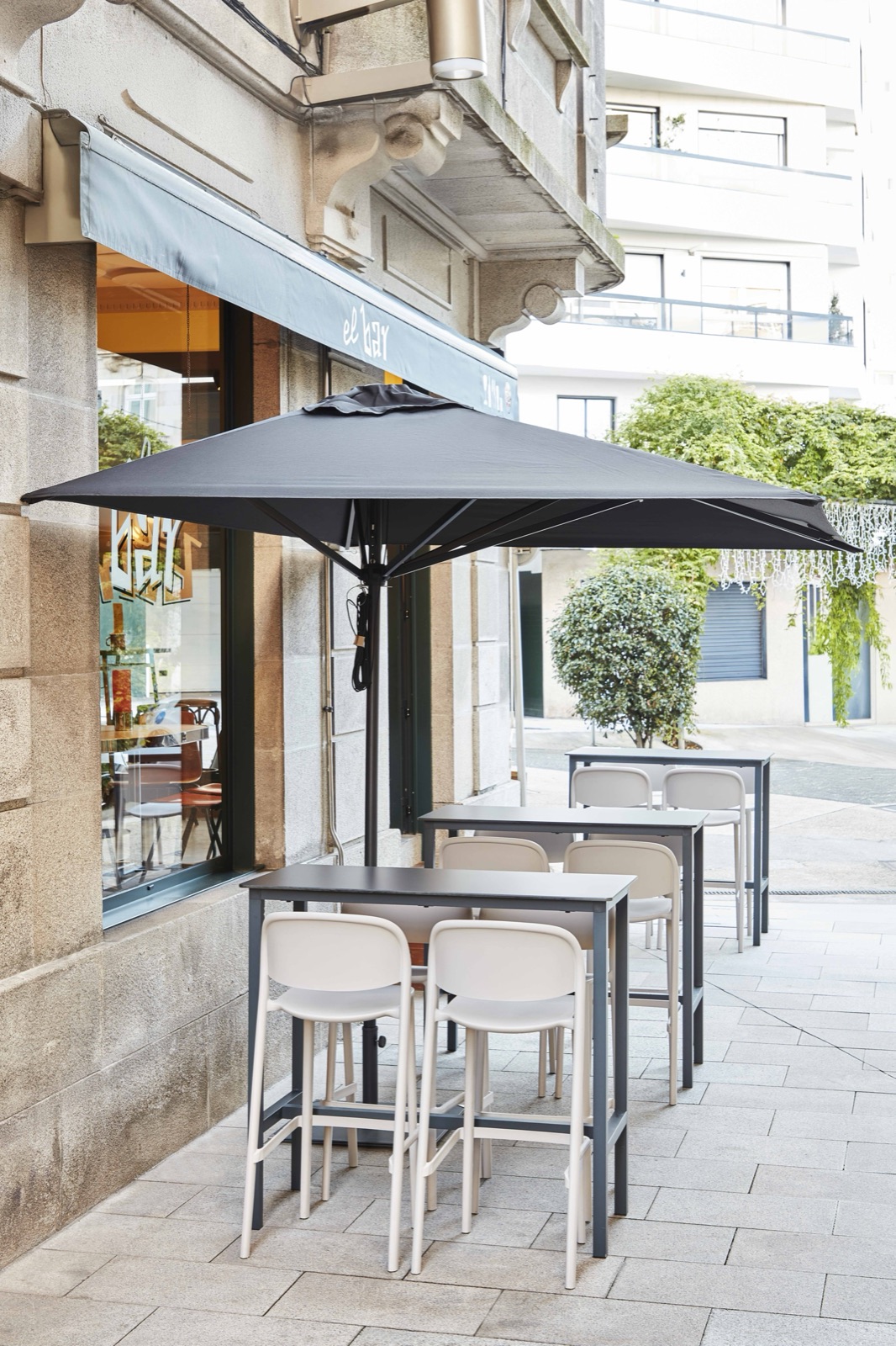 Street terrace bar shaded by a centre-post parasol