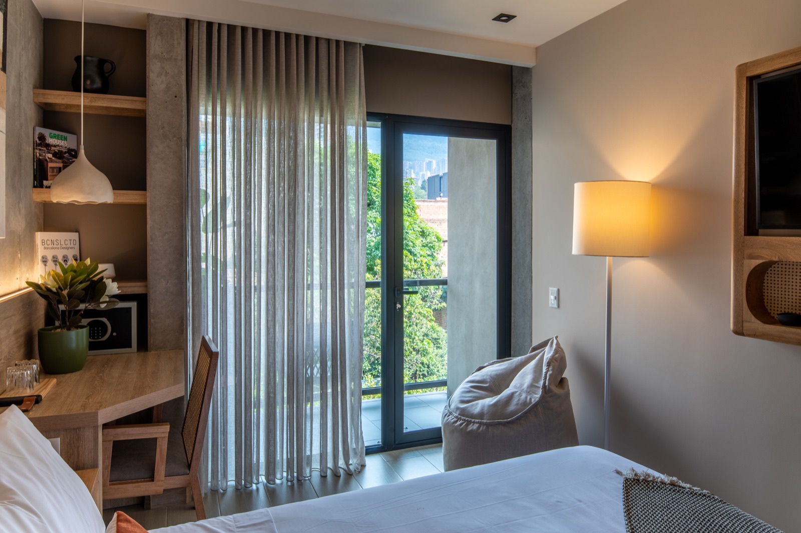 Hotel suite with sheer drapes opening to a balcony